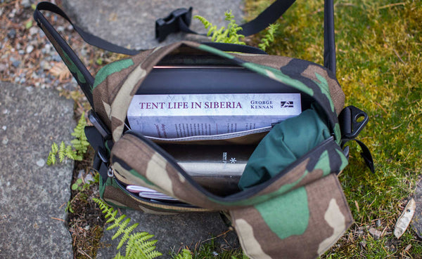 Photo of the LGD in Beaver Camo 1000d. Various items packed inside, including a book, iPad, thermos, and rain shell.